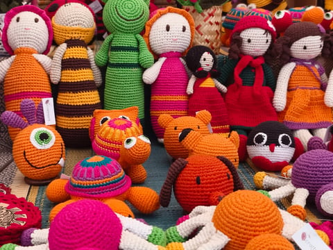 Colorful handmade knitted dolls showcase at the fair